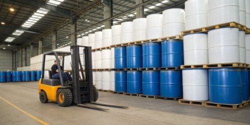 A forklift moving barrels of PU foam chemicals in a warehouse