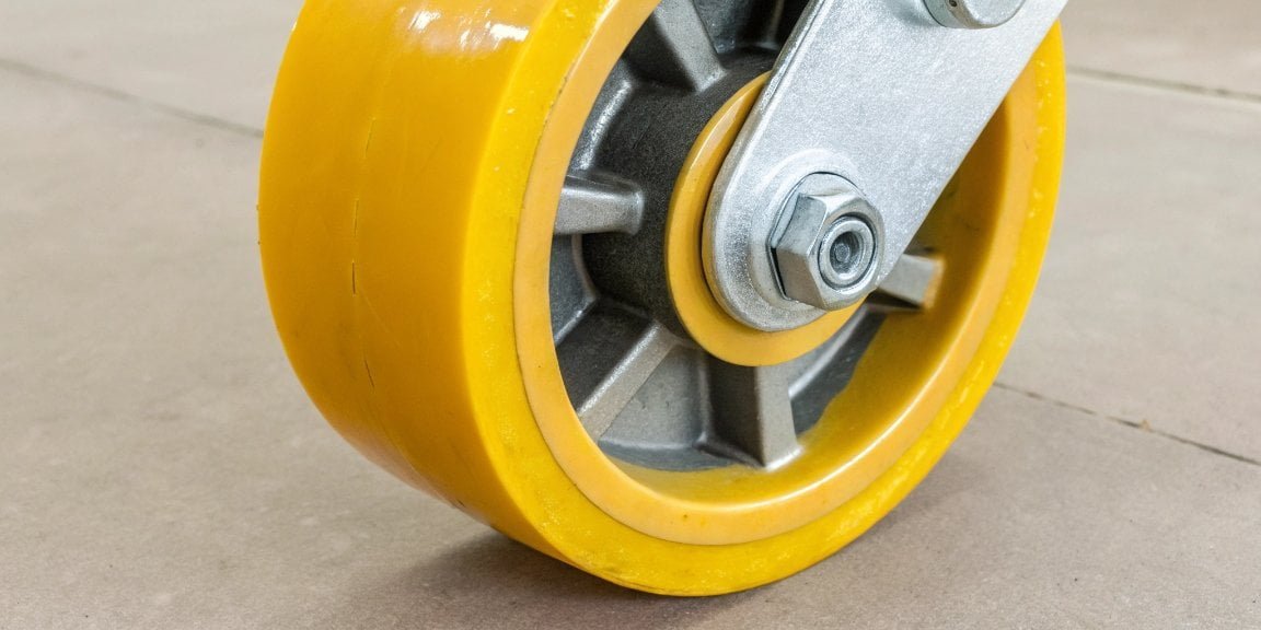A close-up of a vibrant yellow polyurethane industrial wheel, showcasing its smooth and tough texture.