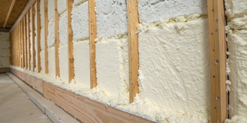 A cross-section of cured spray foam insulation on a wall stud