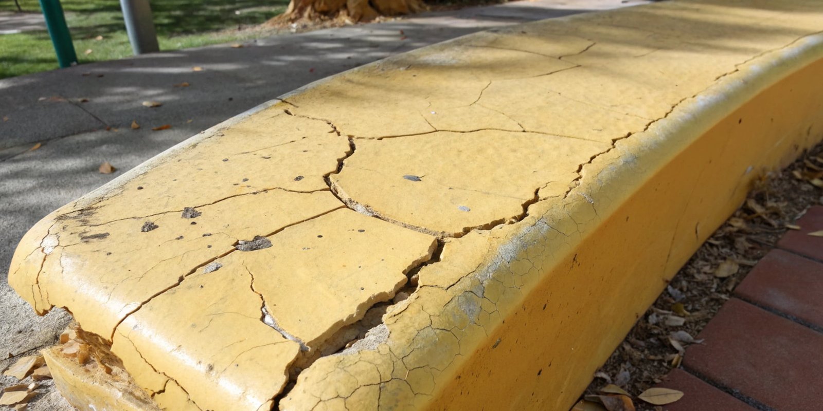 A piece of yellowed and cracked polyurethane that has been left outdoors, showing UV damage.