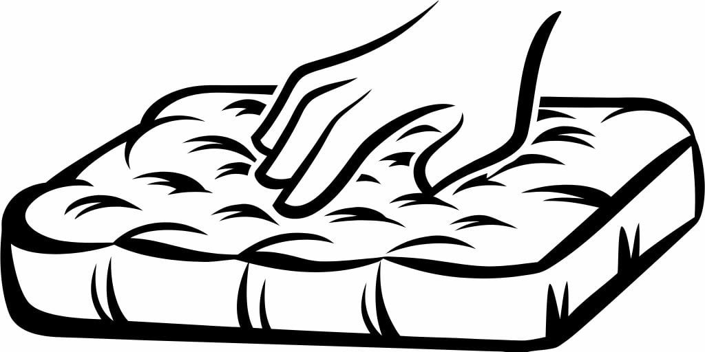 A hand pressing into a soft, high-density memory foam mattress topper