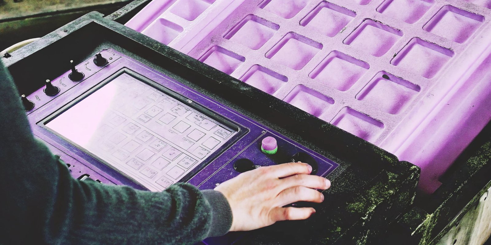 An operator using the touch screen of a PU machine with a mold in the background